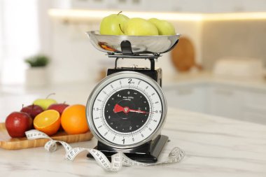 Elmalı mutfak pulları ve kapalı alandaki hafif mermer masada mezura.