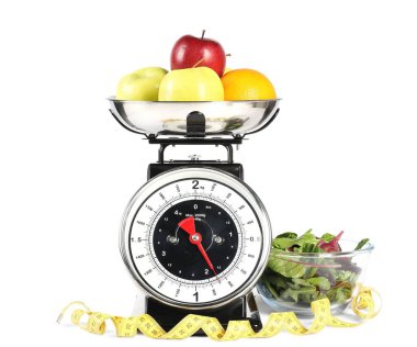 Meyveli mutfak pulları, mezura ve yeşillikler beyaz kasede izole edilmiş.