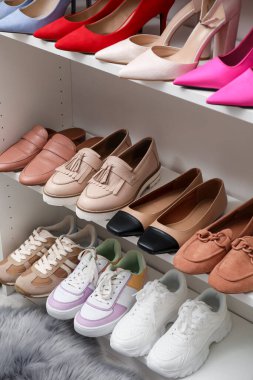 Ayakkabı deposu. Bir sürü farklı ayakkabı çifti olan raf ünitesi kapalı, yakın plan.