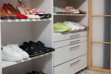 Ayakkabı deposu. Bir sürü farklı ayakkabı çifti olan raf ünitesi kapalı, yakın plan.