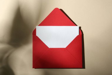 Bej arka planda boş tebrik kartı ve kağıt zarf, üst görünüm