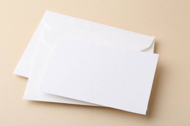 Bej arkaplanda boş tebrik kartı ve zarflar, yakın plan