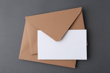 Gri arkaplanda boş tebrik kartı ve zarflar, üst görünüm