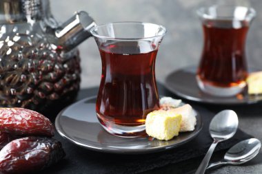 Lezzetli Türk çayı Gri masada şekerlerle servis edilir, yakın plan.