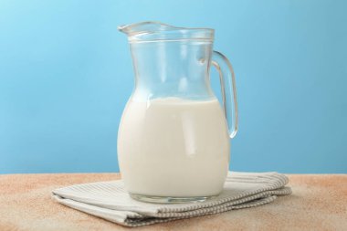Masadaki taze süt açık mavi arka planda, yakın plan.