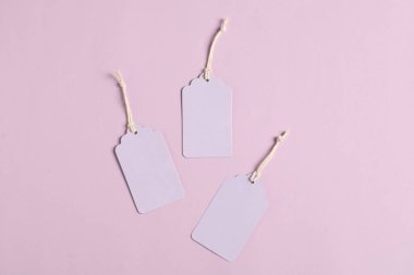 Soluk menekşe arkaplanda dizgileri olan boş etiketler, düz yatıyordu