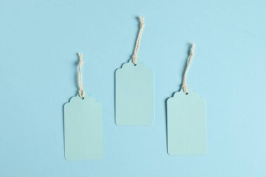 Açık mavi arkaplanda dizgileri olan boş etiketler, düz yatıyordu