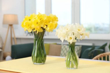 Evdeki masadaki cam vazolarda güzel nergisler.