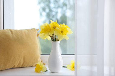 Evdeki pencere eşiğinde vazodaki güzel nergisler