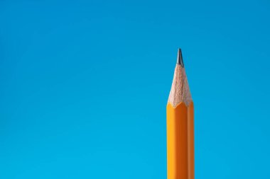 Açık mavi arkaplanda keskin grafit kalem, yakın plan. Metin için boşluk