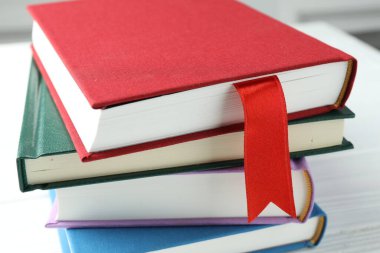 Kırmızı kurdele yer imi ve beyaz ahşap masada renkli olanlar, yakın plan.