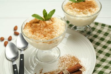 Tarçınlı, naneli, bademli ve kaşıklı lezzetli sütlaç, yakın plan.