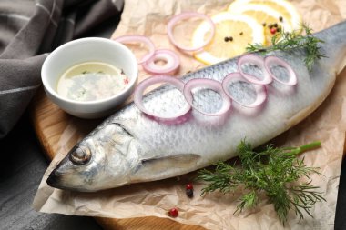 Lezzetli ringa balığı, siyah masada baharatlar, yakın plan