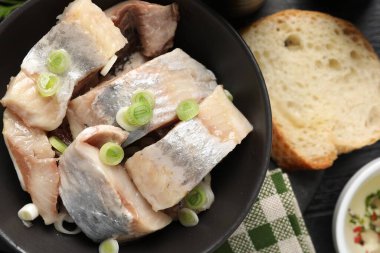 Siyah masada yeşil soğanlı lezzetli ringa balıkları.