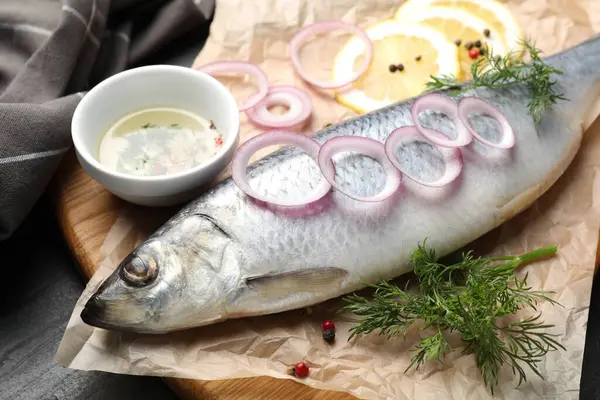 Lezzetli ringa balığı, siyah masada baharatlar, yakın plan