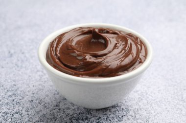 Açık gri desenli masada, kasede nefis çikolatalı puding, yakın plan.