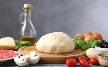 Pizza yapıyorum. Gri masadaki farklı malzemeler