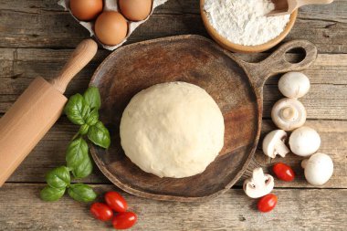 Pizza yapıyorum. Tahta masadaki farklı malzemeler.