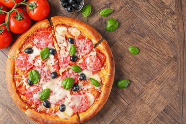 Lezzetli pizza ve malzemeler ahşap masada, düz yerde. Metin için boşluk