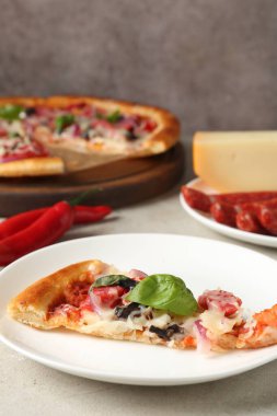 Hafif masada servis edilen ince tütsülenmiş sosisli, lezzetli bir pizza.