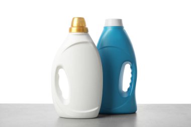 Beyaz arkaplana karşı gri masada yumuşatıcı şişeler