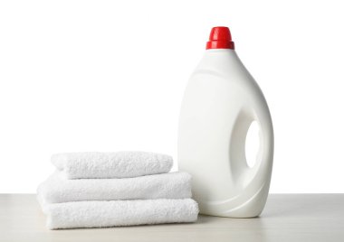 Bir şişe yumuşatıcı ve beyaz üzerine izole edilmiş havlular.