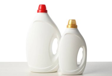 Beyaz arka plana karşı ahşap masada yumuşatıcı şişeler.