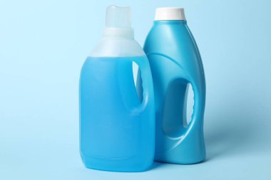 Açık mavi arkaplanda yumuşatıcı şişeler