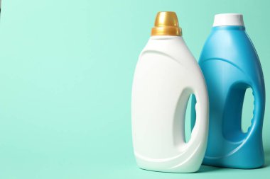 Turkuaz arka planda yumuşatıcı şişeler, metin için boşluk