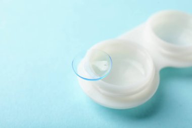 Kontak lensler ve ışık turkuaz arka planda çanta, yakın plan. Metin için boşluk