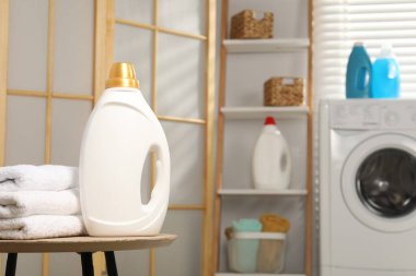 İçerideki masada yumuşatıcı ve havlu şişesi, metin için yer var.