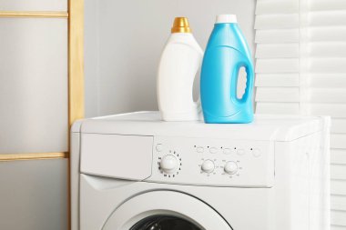 Çamaşır makinesinde yumuşatıcı şişeler.