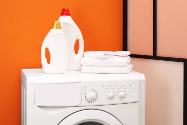 İçerideki çamaşır makinesinde yumuşatıcı ve havlu şişeleri.