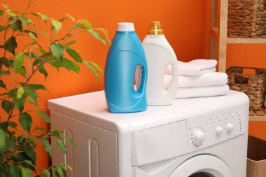 İçerideki çamaşır makinesinde yumuşatıcı ve havlu şişeleri.