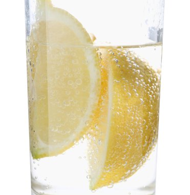Beyaz arka planda limon dilimleri ile soda tazeleniyor, yakın plan.