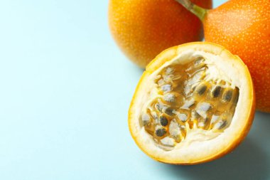 Açık mavi arka planda olgun sarı çarkıfelek meyveleri, yakın plan. Metin için boşluk