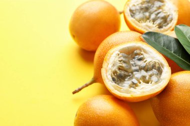 Sarı arka planda olgun çarkıfelek meyveleri ve yaprakları, yakın plan. Metin için boşluk