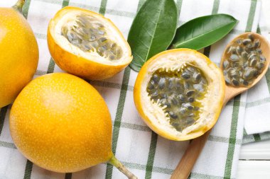 Olgun tutku meyveleri, yeşil yapraklar ve tohumlar masada, düz yerde