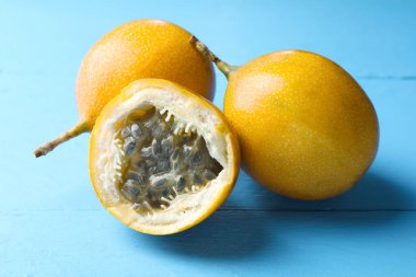 Açık mavi ahşap masada olgun tutku meyveleri, yakın plan.