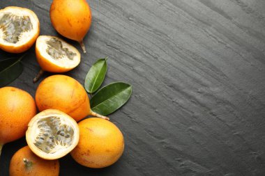 Olgun çarkıfelek meyveleri ve yaprakları siyah masanın üstünde, dümdüz yatıyordu. Metin için boşluk