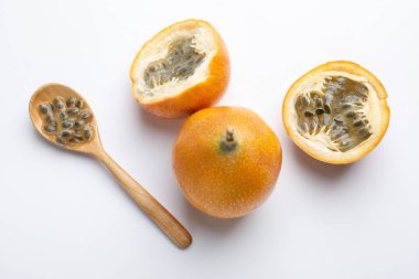 Olgun tutku meyveleri, tohumlar ve kaşıklar beyaz arka planda, düz yatıyordu.