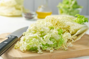 Beyaz masada Çin lahanası ve bıçağı kes, yakın plan.