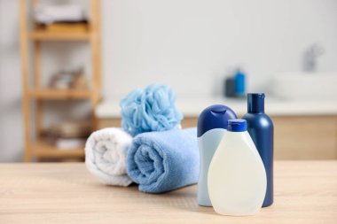 Banyodaki hafif ahşap masada farklı banyo ürünleri.