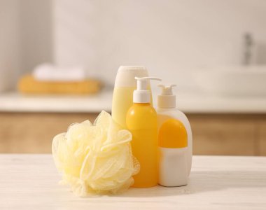 Banyodaki beyaz ahşap masada farklı banyo ürünleri.