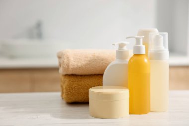 Banyodaki beyaz ahşap masada farklı banyo ürünleri. Metin için boşluk