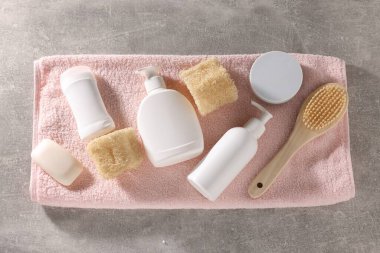 Gri desenli arka planda farklı banyo aksesuarları, düz yatış