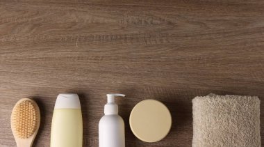 Ahşap arka planda farklı banyo aksesuarları, düz yatış. Metin için boşluk