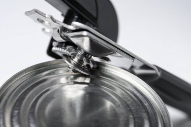 Konserve açacağı ve teneke kutu beyaz masada, yakın plan.