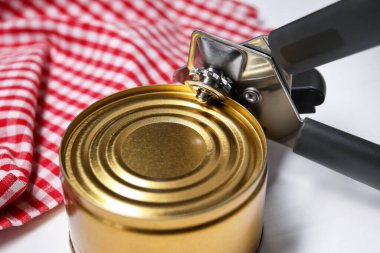 Konserve açacağı ve teneke kutu beyaz masada, yakın plan.