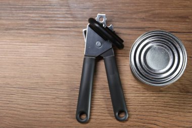 Konserve açacağı ve teneke kutu, ahşap masa, üst manzara. Metin için boşluk